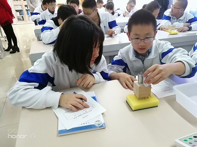 学生完成影响压强大小因素的探究实验.jpg